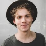 man standing near white wall